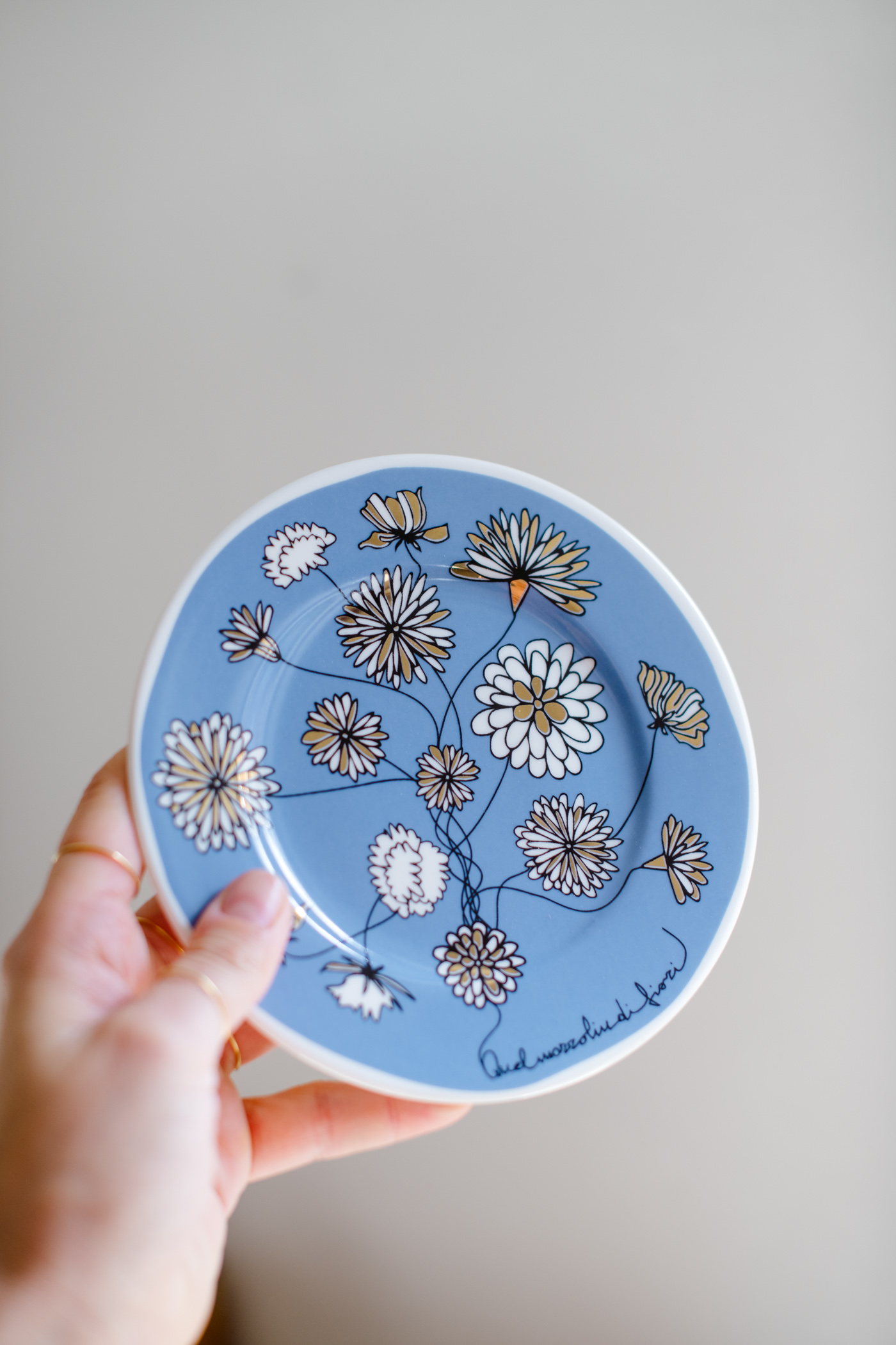 piatto in porcellana con dettagli oro, disegno mazzolino di fiori su fondo azzurro