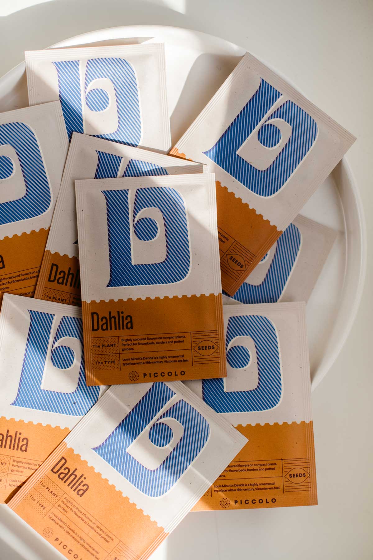 semi di dalia, pianta fiorita perenne, packaging in carta con indicazioni su semina e cura della pianta